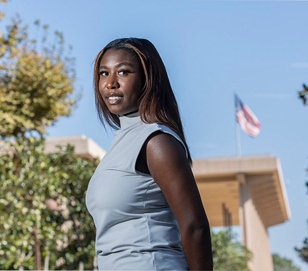 Kaitlyn Bryant in the foreground, the University Library with the American flag flying in the background.