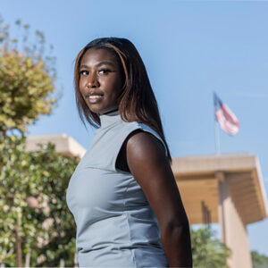 Kaitlyn Bryant in the foreground, the University Library with the American flag flying in the background.