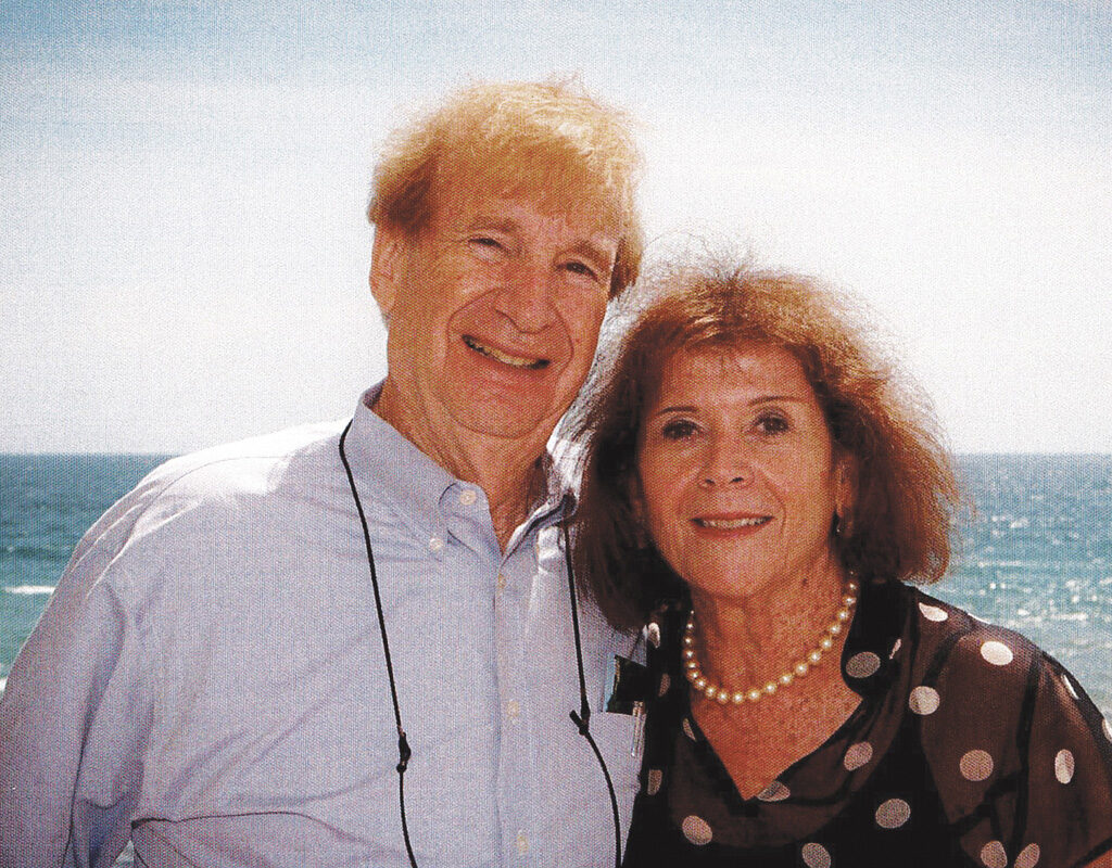 Shepard and Ronni Goodman stand together in front of an ocean. 