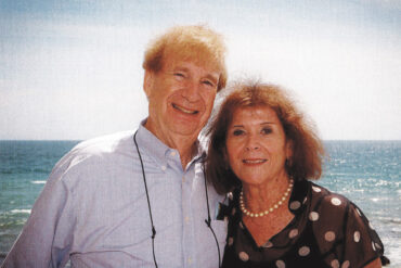 Shepard and Ronni Goodman stand together in front of an ocean.