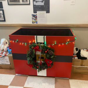 A red toy box decorated with a string of lights.