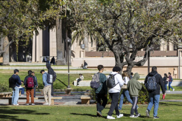 Students walk on campus near the University Library.