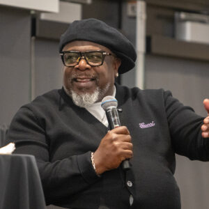 Cedric the Entertainer, seated, holds a microphone.
