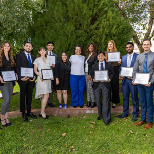 Students, holding certificates, pose for a group photo with scholarship benefactors.
