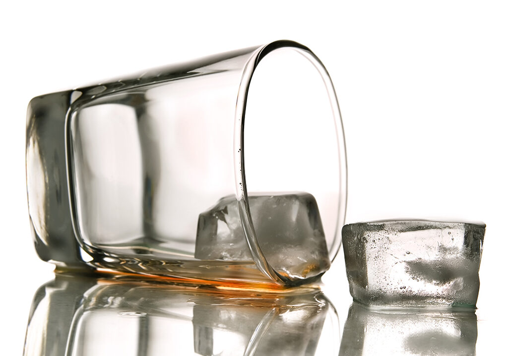 Toppled glass spilling liquid with ice