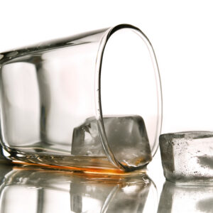 Toppled glass spilling liquid with ice