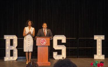 Marquita Gammage, professor of Africana Studies and director of the Ethnic Studies Center for Research, Activism and Community Engagement, and Freddie Sanchez, associate vice president for Student Affairs, Equity and Inclusion, stand at a wooden podium in front of large, white letters that spell out BSI: Black Serving Institution.