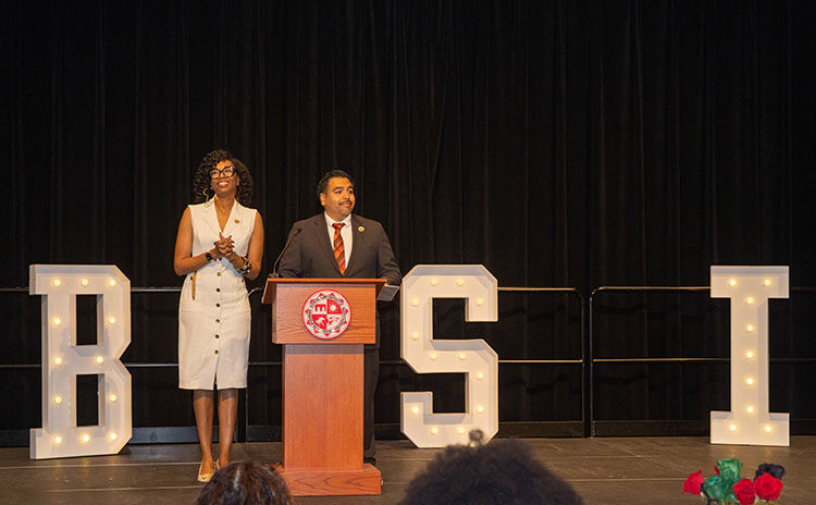 Marquita Gammage, professor of Africana Studies and director of the Ethnic Studies Center for Research, Activism and Community Engagement, and Freddie Sanchez, associate vice president for Student Affairs, Equity and Inclusion, stand at a wooden podium in front of large, white letters that spell out BSI: Black Serving Institution.