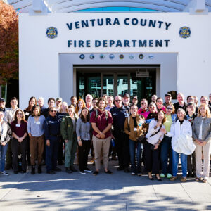Large group of people gathered for a photo with the Ventura Cunty Fire Department building in the background.