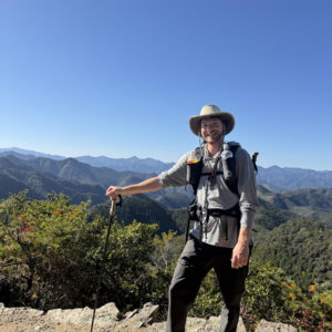 A man at a high point on a wilderness hike.