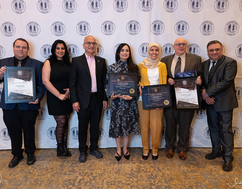 A group of people, some holding certificates, smile and pose for a photo.