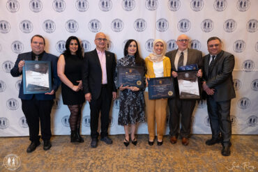 A group of people, some holding certificates, smile and pose for a photo.