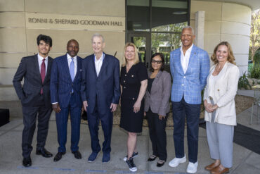 A group of well-dressed university officials in front of a building.