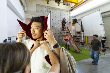A man gets his Ming the Merciless costume adjusted during a photo shoot.