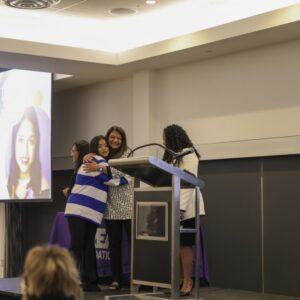 Student Karla Moreno hugs Senior Director of the Equal Opportunity Program Shiva Parsa as Moreno is recognized for receiving the scholarship. CREA Foundation Executive Director Arvetta Jideonwo stands along side the pair on the stage. Photos provided by Crystal Gomez.