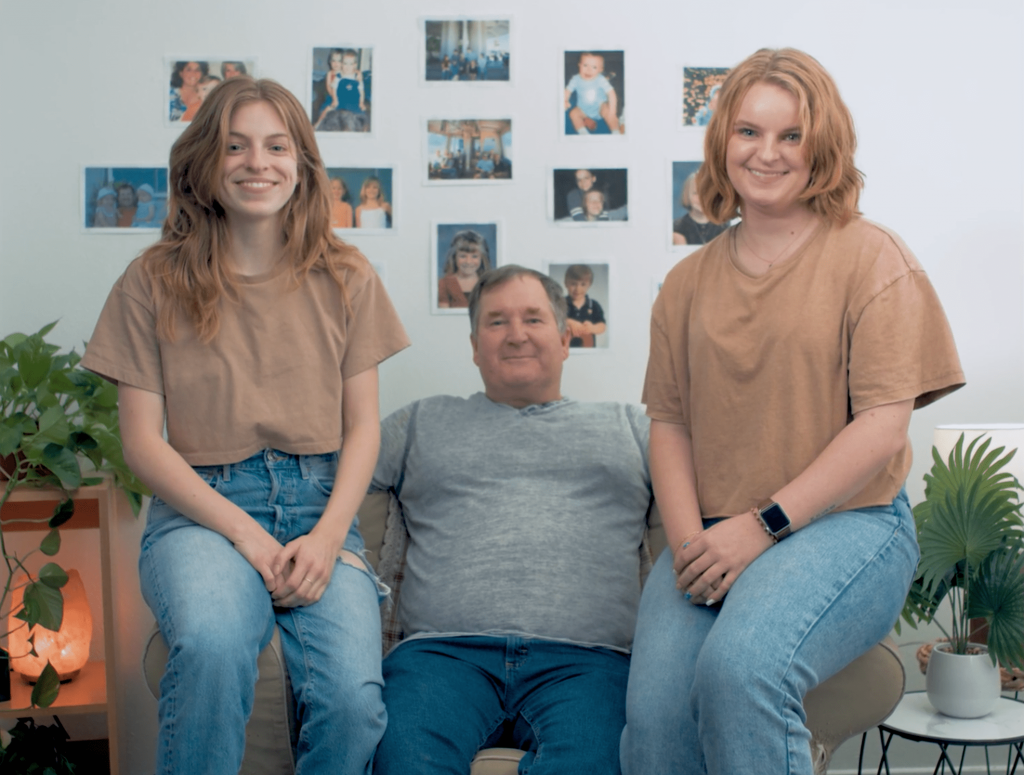 Haily, Steve and Sara Sims are all seated on a chair smiling at the camera. The image was taken from the last shot of Sims’ short film ‘#2276.’