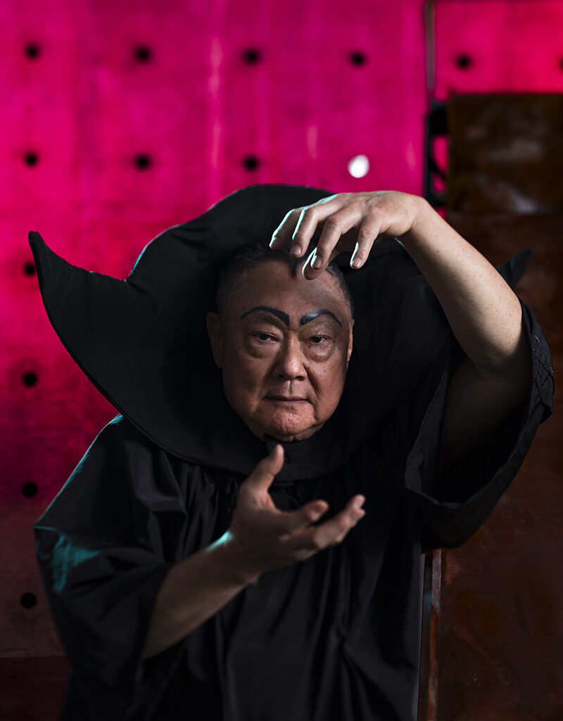 Bruce Yonemoto in a black tunic and collar as Flash Gordon villain Ming the Merciless.