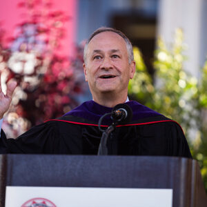 Doug Emhoff stands at podium on the commencement stage.