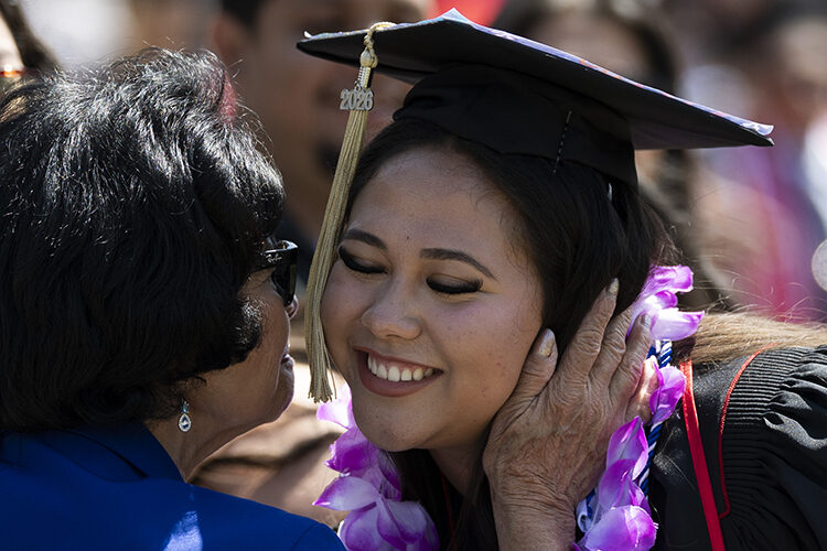 A CSUN graduate shares an emotional moment with a relative.