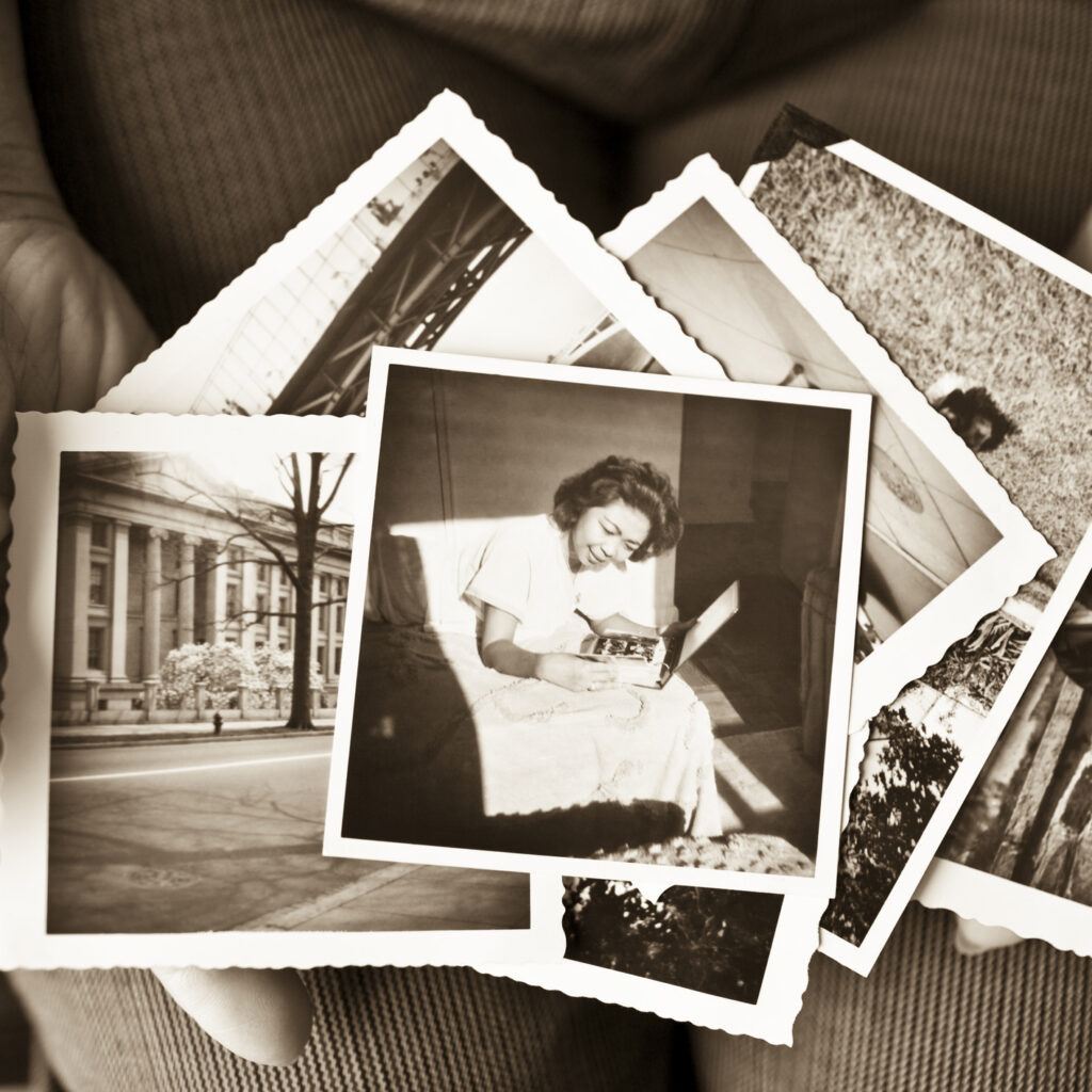 Elderly woman holding a collection of old photographs