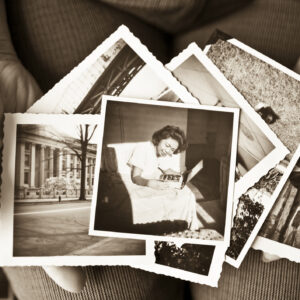 Elderly woman holding a collection of old photographs