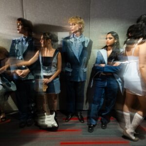 A motion blurred image of models in line at a fashion show.