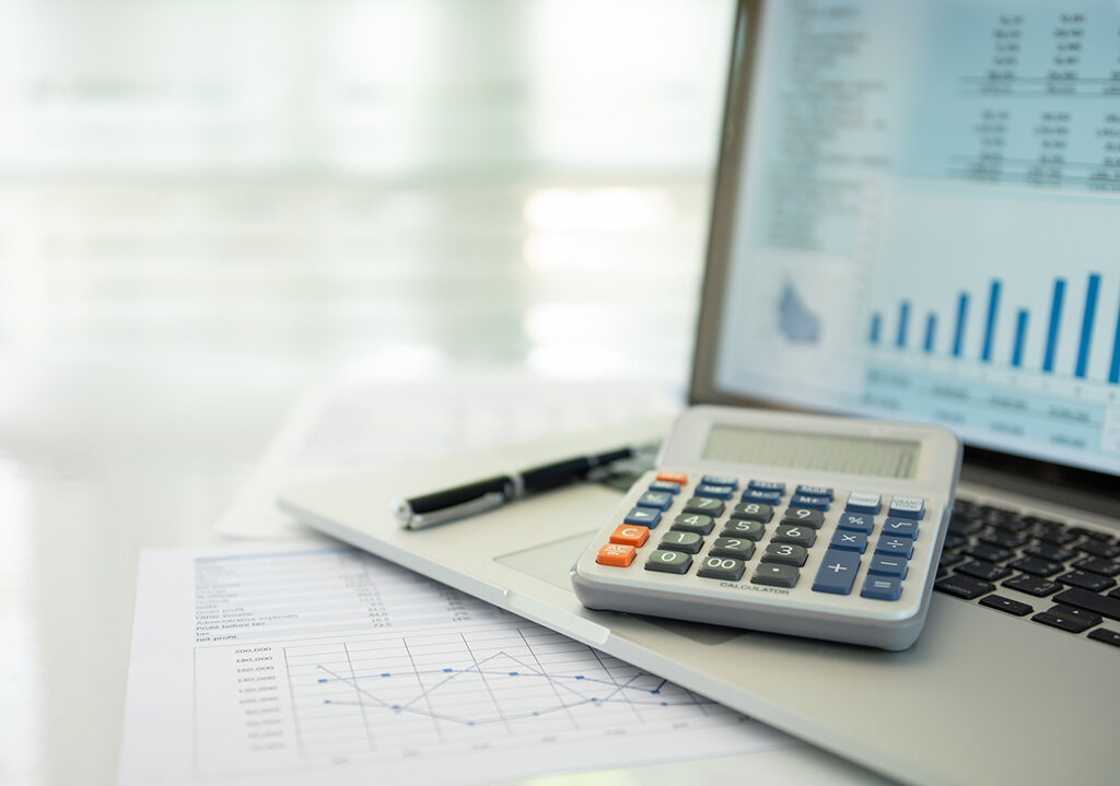 calculator, account statement and business report with financial budget portfolio show on screen laptop computer. accounting business concept.