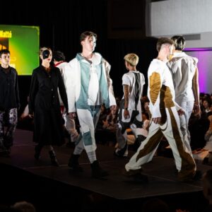 Models wearing white and dark menswear luxury streetwear on a fashion runway.