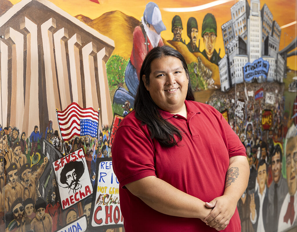 Anthony Cerrato, stands in front of a colorful mural.