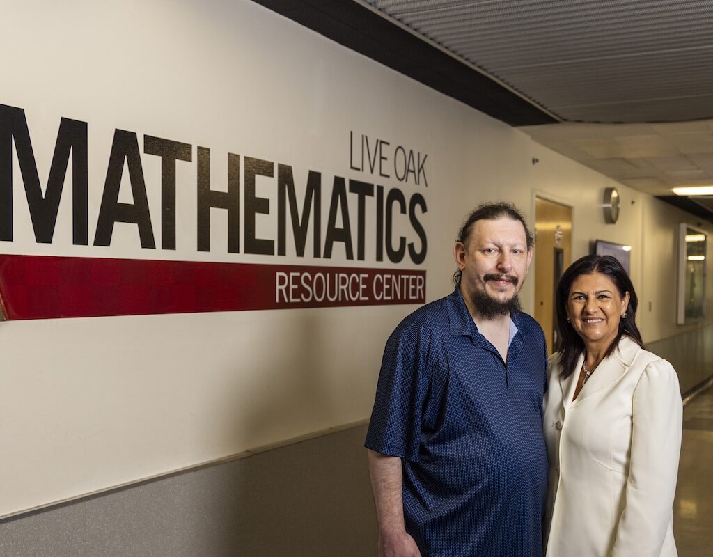 A man and woman pose in a hallway outside CSUN's Math Resource Center