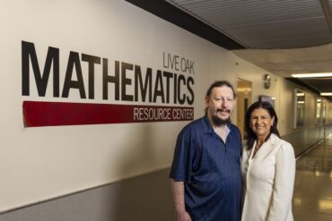 A man and woman pose in a hallway outside CSUN's Math Resource Center