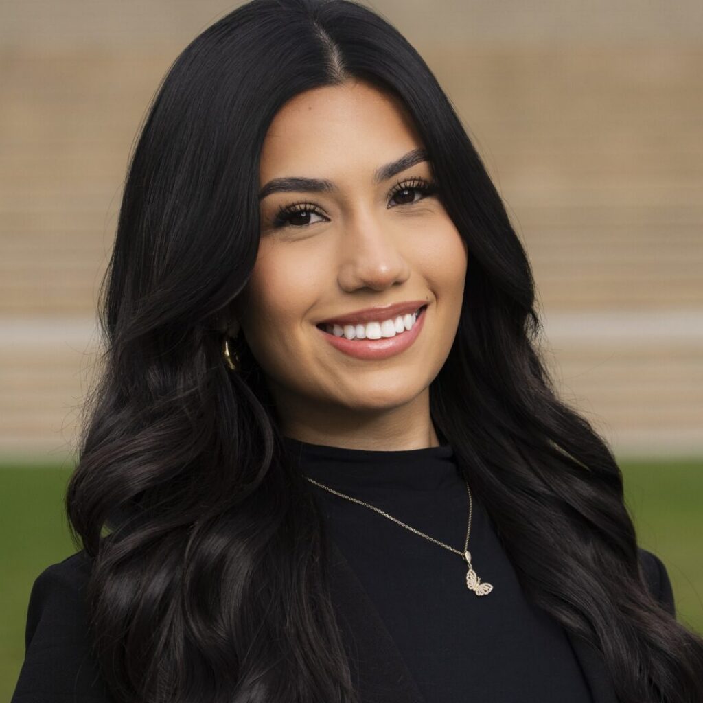 A female student poses for a portrait in front of the University Library steps.